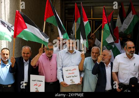 Gaza, Palestine, 29 mai 2022. Les Palestiniens brandissent leur drapeau national dans la ville de Gaza pour protester dimanche contre la marche du drapeau israélien dans la vieille ville de Jérusalem. La Marche du drapeau est un événement annuel marquant la prise de Jérusalem-est par Israël en 1967, avec des nationalistes israéliens de droite chantant et dansant pendant le rassemblement et insultant les Palestiniens. La tension déjà élevée dans la région a été aggravée par la prise d'assaut par des ultranationalistes israéliens et des colons israéliens de l'enceinte de la mosquée Al-Aqsa, avant et pendant la marche Banque D'Images