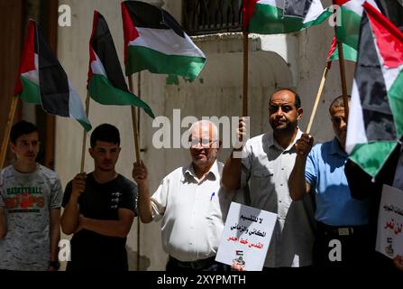 Gaza, Palestine, 29 mai 2022. Les Palestiniens brandissent leur drapeau national dans la ville de Gaza pour protester dimanche contre la marche du drapeau israélien dans la vieille ville de Jérusalem. La Marche du drapeau est un événement annuel marquant la prise de Jérusalem-est par Israël en 1967, avec des nationalistes israéliens de droite chantant et dansant pendant le rassemblement et insultant les Palestiniens. La tension déjà élevée dans la région a été aggravée par la prise d'assaut par des ultranationalistes israéliens et des colons israéliens de l'enceinte de la mosquée Al-Aqsa, avant et pendant la marche Banque D'Images