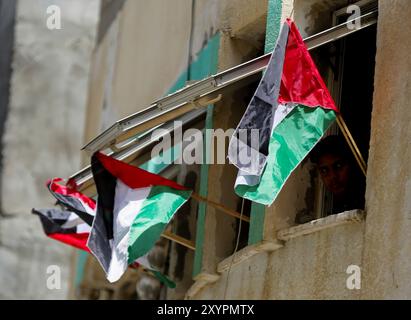 Gaza, Palestine, 29 mai 2022. Les Palestiniens brandissent leur drapeau national dans la ville de Gaza pour protester dimanche contre la marche du drapeau israélien dans la vieille ville de Jérusalem. La Marche du drapeau est un événement annuel marquant la prise de Jérusalem-est par Israël en 1967, avec des nationalistes israéliens de droite chantant et dansant pendant le rassemblement et insultant les Palestiniens. La tension déjà élevée dans la région a été aggravée par la prise d'assaut par des ultranationalistes israéliens et des colons israéliens de l'enceinte de la mosquée Al-Aqsa, avant et pendant la marche Banque D'Images