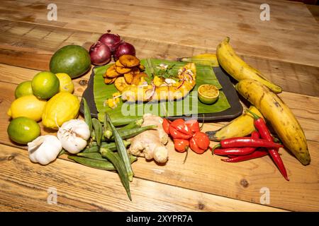 Un délicieux plat de poisson frit et d'inspiration ouest-africaine Frites avec tranches de banane frites servies sur une feuille de banane Banque D'Images