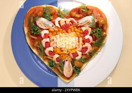 Pizza appétissante et colorée en forme de coeur avec des crevettes sur une assiette de nourriture conceptuelle exotique nature morte Banque D'Images