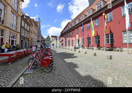 Hôtel de ville rouge et maisons historiques à pignons au marché de Greifswald, support de vélos avec des vélos rouges, Mecklembourg-Poméranie occidentale, Allemagne, Europe Banque D'Images