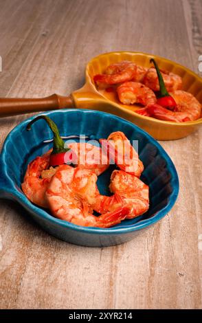 Délicieux gambas black tiger en pan de céramique colorée sur une table en bois Banque D'Images