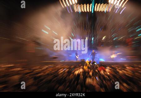 Groupe de rock se produisant sur une scène éclairée par des lumières colorées L'image a un effet zoom dynamique artistique Banque D'Images
