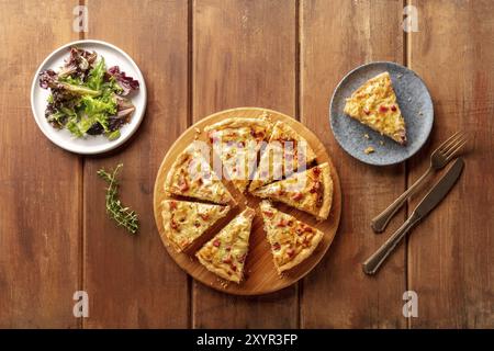 Une photo d'un appareil à quiche avec salade mesclun de feuilles, tourné par le haut sur un fond de bois rustique foncé avec une place pour le texte Banque D'Images