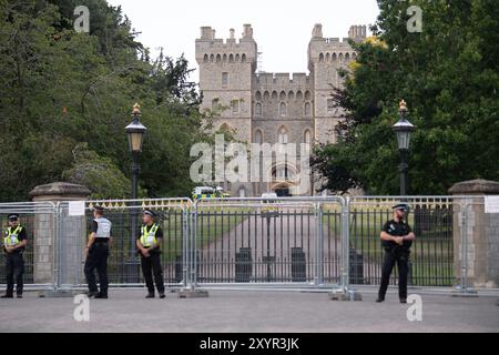 Windsor, Royaume-Uni. 30 août 2024. Extinction Rebellion a organisé une manifestation sur la longue marche avec pour toile de fond le château de Windsor à Windsor, Berkshire ce soir. Les manifestants climatiques de XR portaient des costumes d'affaires et s'habillaient en barons du pétrole, en magnats des médias et en financiers sans visage. Les Oil Slicks, habillés de costumes noirs avec de la peinture de visage noir et blanc, ont réalisé une action théâtrale chorégraphiée dans le but de mettre en évidence le récit XR pour la journée, que le système est brisé. Les rebelles XR campent à Home Park en face du château de Windsor aujourd'hui et pendant le week-end dans le cadre de leur surclassement de trois jours Banque D'Images