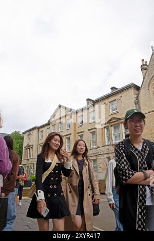 Vue verticale de jeunes étudiantes chinoises marchant le long de Cornmarket Street dans le centre-ville d'Oxford Oxfordshire Angleterre Royaume-Uni 2024 KATHY DEWITT Banque D'Images