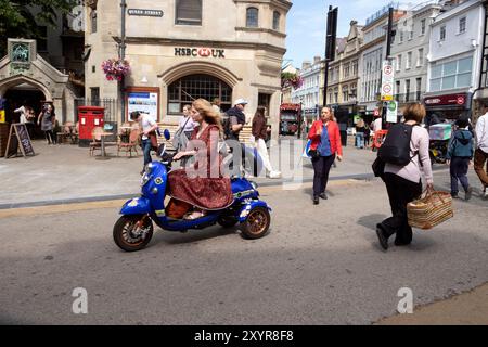 Femme portant jolie robe chevauchant scooter électrique de mobilité sur Queen Street dans Oxford City Centre Oxfordshire Angleterre Royaume-Uni Grande-Bretagne KATHY DEWITT Banque D'Images