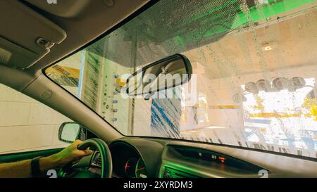 Santa Maria, Californie, États-Unis. 26 juillet 2024. Vue intérieure d'une voiture en cours de lavage, avec de la mousse et de l'eau recouvrant le verre. Banque D'Images