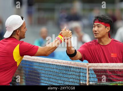 Paris, France. 30 août 2024. Ji Zhenxu, de Chine, serre la main à Enrique Siscar Meseguer, d'Espagne, après leur match de premier tour en simple masculin de tennis en fauteuil roulant aux Jeux paralympiques de Paris 2024 à Paris, France, le 30 août 2024. Crédit : HE Canling/Xinhua/Alamy Live News Banque D'Images