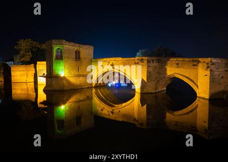 St Ives, Cambridgeshire, Royaume-Uni. 30 août 2024. Météo britannique. Le pont St Ives illuminé du XVe siècle se reflète dans l'eau calme de la rivière Great Ouse par une nuit calme et paisible avec une brise légère. Le pont du XVe siècle est l'un des quatre ponts en Angleterre à intégrer une chapelle (les autres étant à Rotherham, Wakefield et Bradford-on-Avon). Crédit photo : Graham Hunt/Alamy Live News Banque D'Images