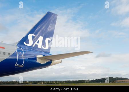 Edimbourg, Écosse - 7 août 2024 : aile de queue et logo de SAS - Scandinavian Airlines - vol d'avion sur un aéroport contre ciel bleu nuageux Banque D'Images