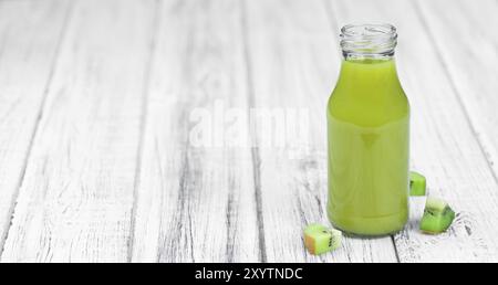 Table en bois avec Smoothie Kiwi fraîche (gros plan, mise au point sélective) Banque D'Images