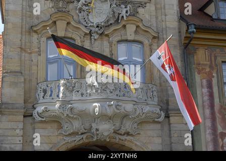 Les drapeaux de l'Allemagne et à l'hôtel de ville de Bamberg, Bamberg, Franconia, Allemagne sur une banque maison de vacances Banque D'Images