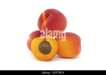 Pile d'abricots mûrs et un coupé en deux pour mettre en valeur son intérieur succulent, isolé sur un fond blanc Banque D'Images