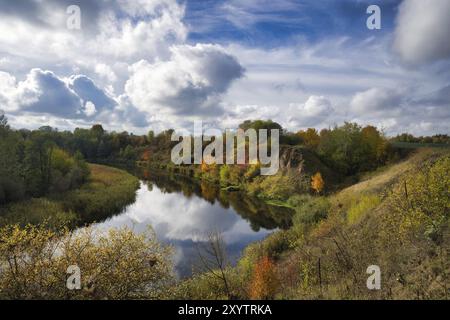 Saison d'automne avec un plan d'eau entouré d'arbres et de buissons par les différentes nuances d'orange et de jaune sur les feuilles des arbres. Calme et reflec Banque D'Images