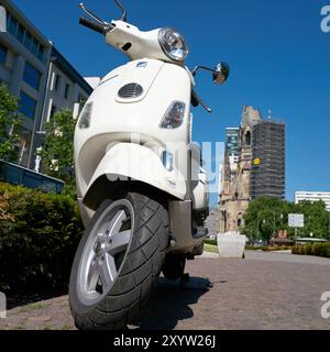 Scooter garé dans le centre-ville de Berlin. En arrière-plan se trouve Breitscheidplatz avec le mémorial Banque D'Images