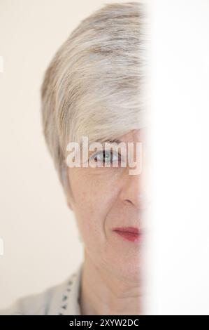 Portrait d'une femme derrière une feuille de papier Banque D'Images