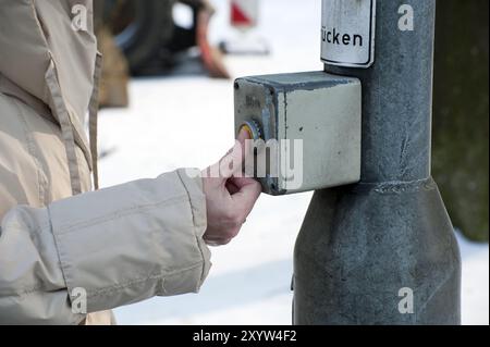 La personne appuie sa main sur le bouton d'un système de feux de signalisation Banque D'Images