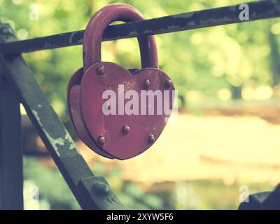Ancien cadenas en forme de coeur utilisé sur un pont, l'amour, de l'image conceptuelle stylisé couleur vintage Banque D'Images