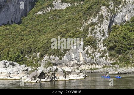 Paysage fluvial avec canoës, forêt, falaises Banque D'Images