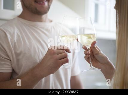 Happy young couple bénéficiant d''un verre de vin blanc à la cuisine Banque D'Images