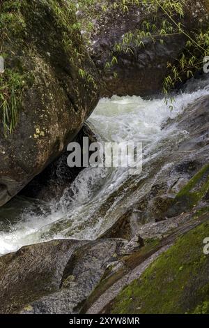 Petite rivière et cascade entre les roches du Parc National d'Itatiaia à Penedo, Rio de Janeiro Banque D'Images