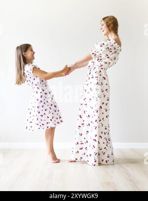 Heureuse mère et fille danser ensemble holding hands Banque D'Images