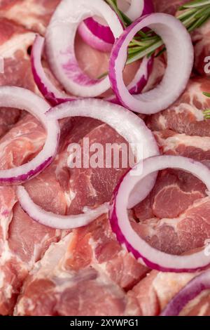 viande de porc tranchée du cou avec oignon rouge, viande de porc molle sur une planche à découper tout en marinant dans les oignons et les épices Banque D'Images