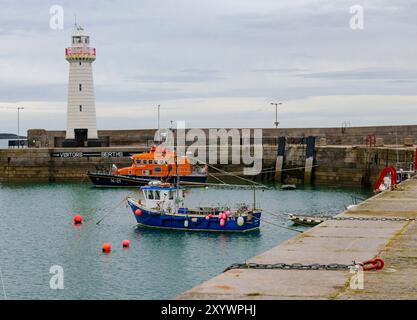 Donaghadee, County Down, Irlande du Nord/22 août 2024 - Donaghadee Lifeboat avec phare en arrière-plan et pêche au premier plan Banque D'Images