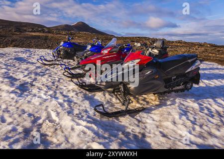 ISLANDE, 04 JUILLET : quatre motoneiges stationnées dans une rangée dans une épaisse neige hivernale en Islande dans un paysage hivernal froid désolant le 04 juillet 2013 à I. Banque D'Images