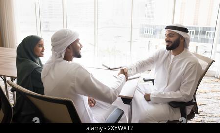 Heureux copropriétaires de la nouvelle société arabe, partenaires serrant la main sur la réunion Banque D'Images