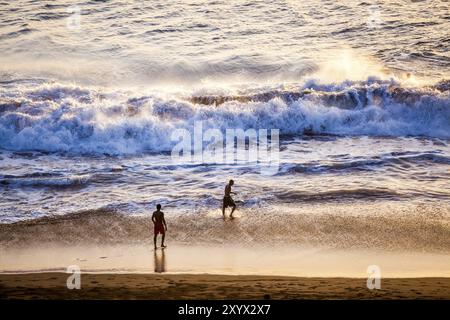 Un groupe de jeunes hommes s'amusant sur la plage Banque D'Images