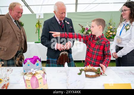 Oliver Keith, 8 ans, de Portlethen, montre au roi Charles III une couronne de papier qu'il a faite à la Royal Horticultural Society of Aberdeen Flower Show à Duthie Park, Aberdeen. Date de la photo : samedi 31 août 2024. Banque D'Images