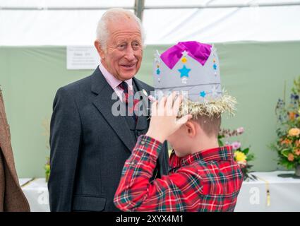 Oliver Keith, 8 ans, de Portlethen, montre au roi Charles III une couronne de papier qu'il a faite à la Royal Horticultural Society of Aberdeen Flower Show à Duthie Park, Aberdeen. Date de la photo : samedi 31 août 2024. Banque D'Images