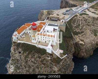 Un phare rouge sur une falaise, entouré de bâtiments blancs et une large vue sur l'océan et le paysage environnant, vue aérienne, phare, Cabo d Banque D'Images