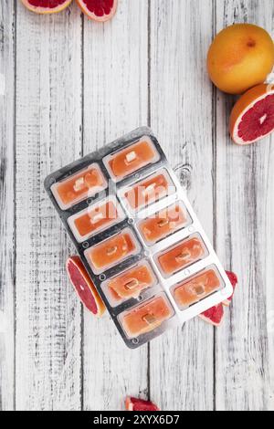 Quelques Popsicles de pamplemousse fraîchement préparées (avec quelques fruits frais, focus sélectif) Banque D'Images