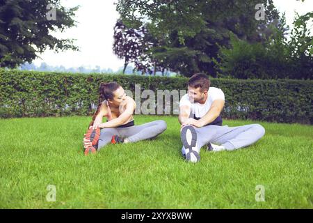 Jeune couple exercising happpy et étirer les muscles avant l'activité sportive Banque D'Images