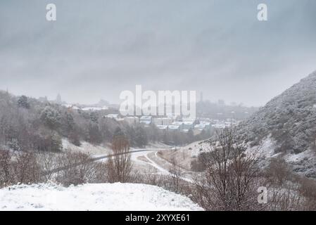 Édimbourg, Écosse, Royaume-Uni - Arthur's Seat et Salisbury Crags dans la neige hivernale, regardant vers la vieille ville Banque D'Images