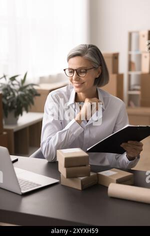 Femme d'affaires mature, propriétaire de petite entreprise gérant des commandes ou des tâches logistiques Banque D'Images