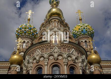 Vue de face d'une église ornée de dômes colorés et de croix dorées sous un ciel nuageux, Saint-Pétersbourg, Russie, Europe Banque D'Images