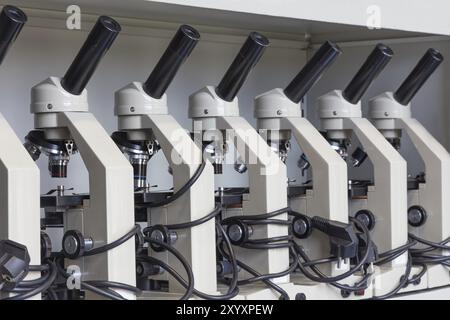 Penderie avec rangée de microscopes, sur l'écart à la biologie dans l'école secondaire Banque D'Images