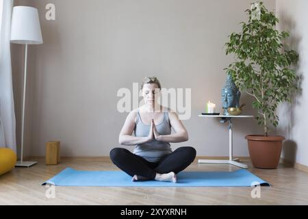 D'âge moyen ou mature woman doing yoga indoors Banque D'Images
