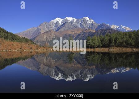 Scène d'automne dans la zone de conservation de l'Annapurna, au Népal. Mont Nilgiri, forêt et lac Sekong Banque D'Images