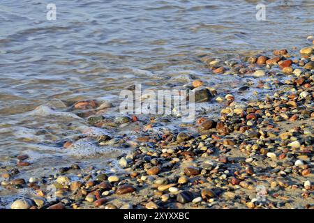 Cailloux colorés sur une plage ensoleillée et la mer surf Banque D'Images