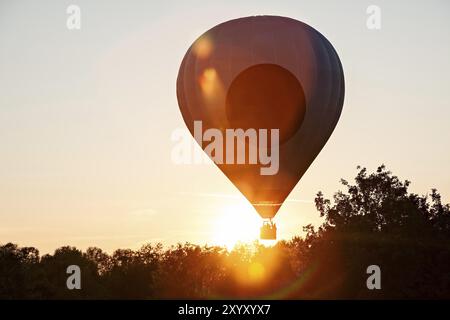 Montgolfière en silhouette prête à se lever en vol contre le soleil Banque D'Images