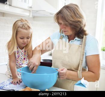 Cute little girl baking avec sa grand-mère à la maison Banque D'Images