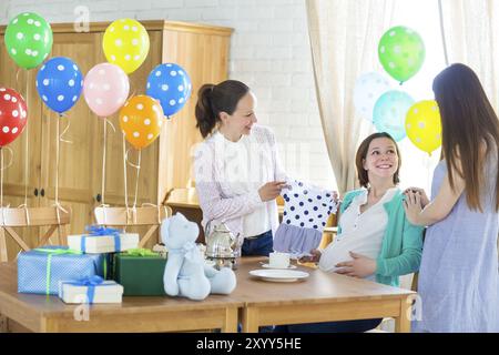 Portrait de femme enceinte avec des amis à une douche de bébé Banque D'Images