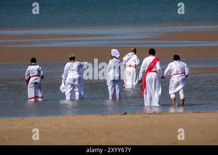 Jesus White Robe Biblical Red Sash ; Christian Group baignant dans la mer à Southport, Royaume-Uni Banque D'Images