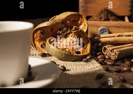 Gros plan sur les fruits d'orange séchée et des bâtons de cannelle avec les grains de café Banque D'Images